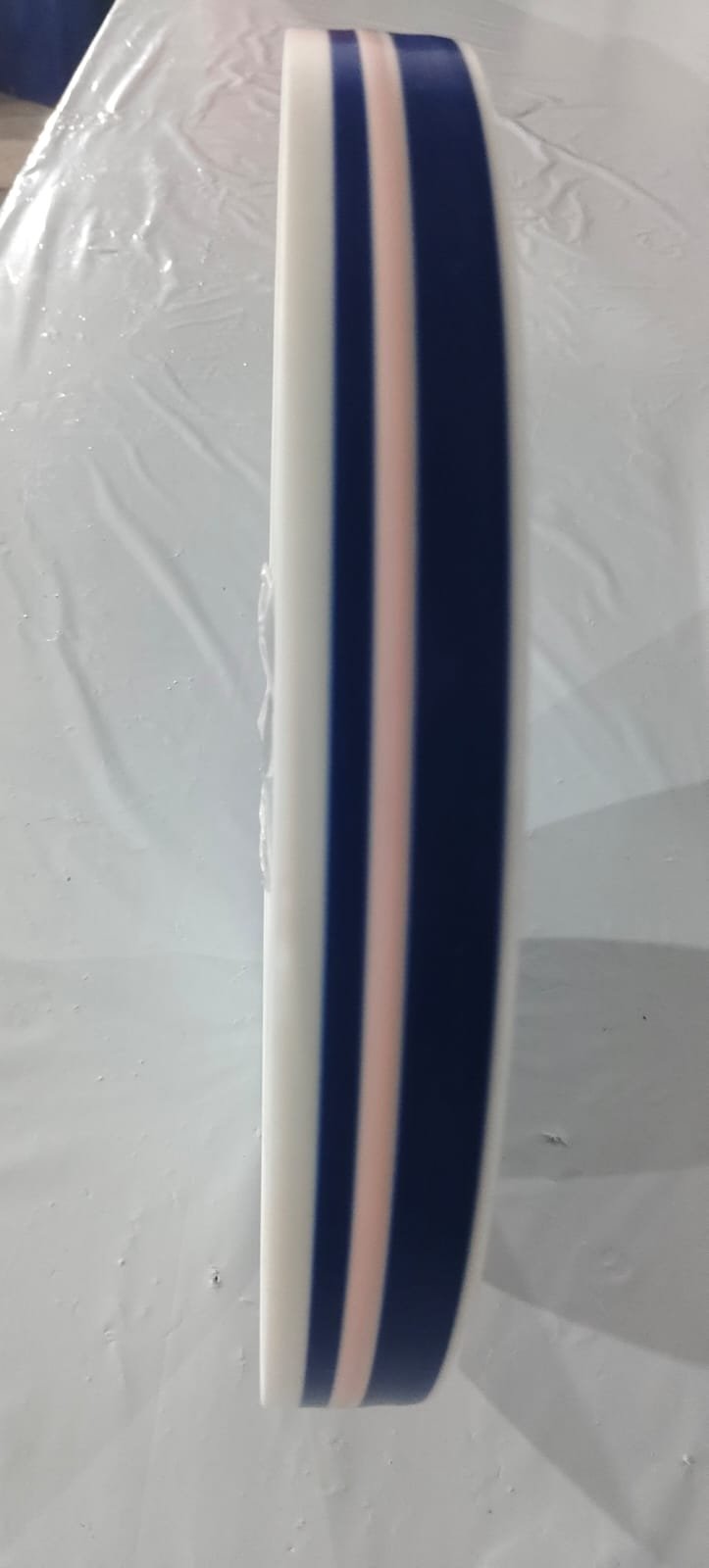 A reel of Level 4 tamper-evident film with the pale indicator stripe running between two printed navy bands